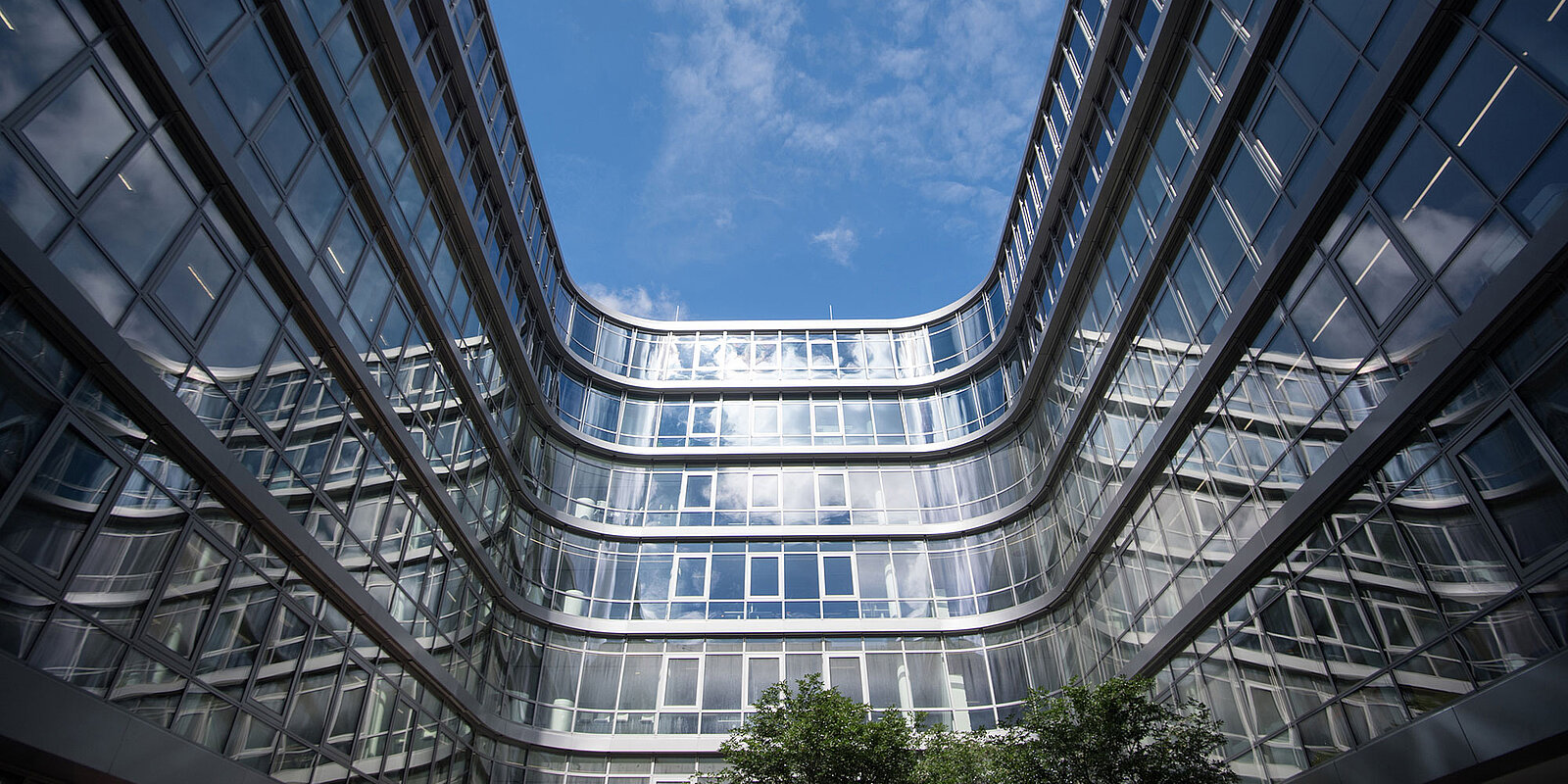 Bäume im offenen Innenhof der Siemens Zentrale umgeben von Glasfassade